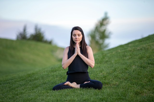 Person sitting quietly near a window during a peaceful morning mental health routine