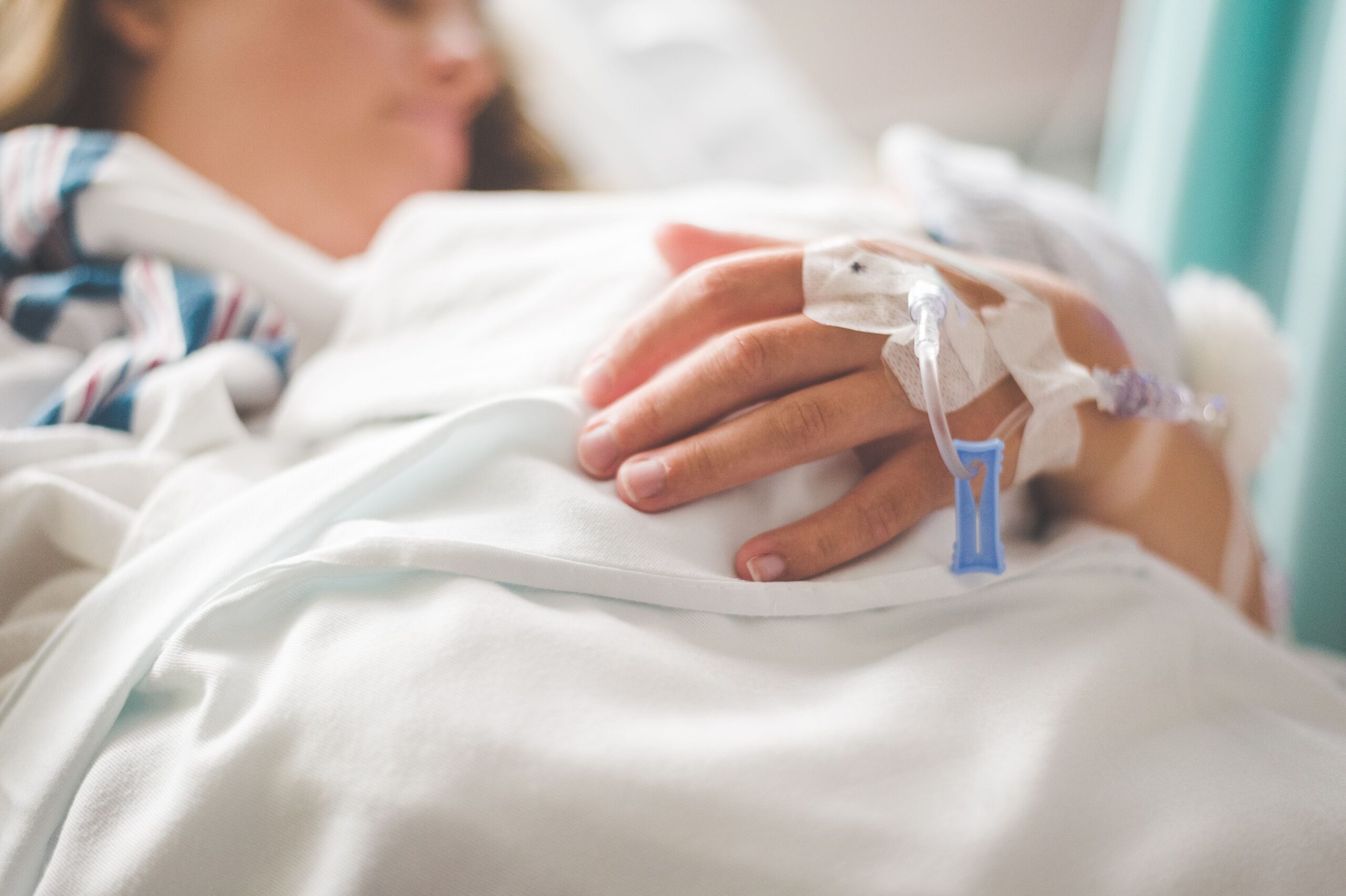 Older adult receiving hospital care while clinicians administer intravenous antibiotics for a serious infection.