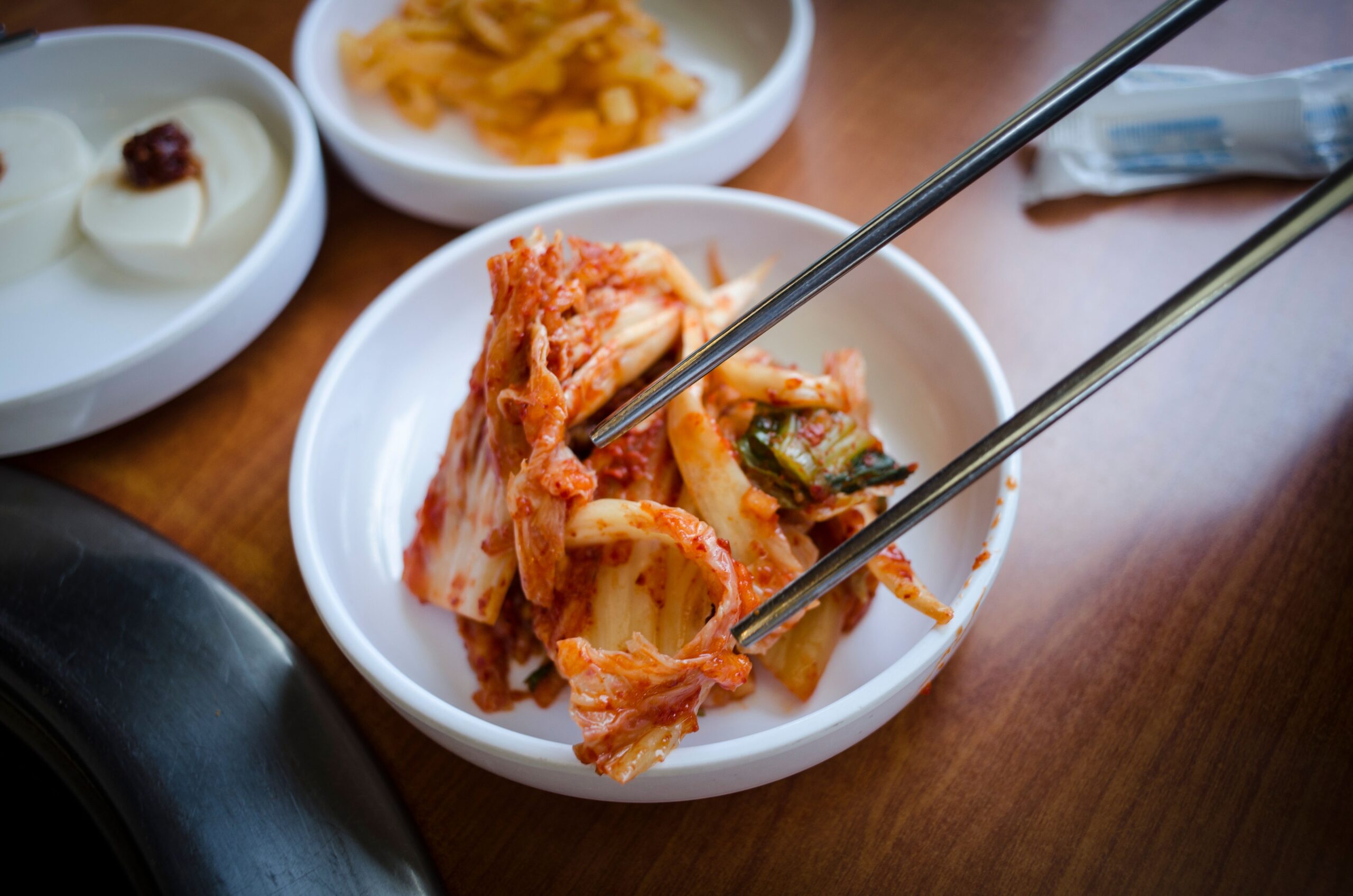 Kimchi in a traditional jar alongside a scientific illustration of microscopic nanoplastic particles