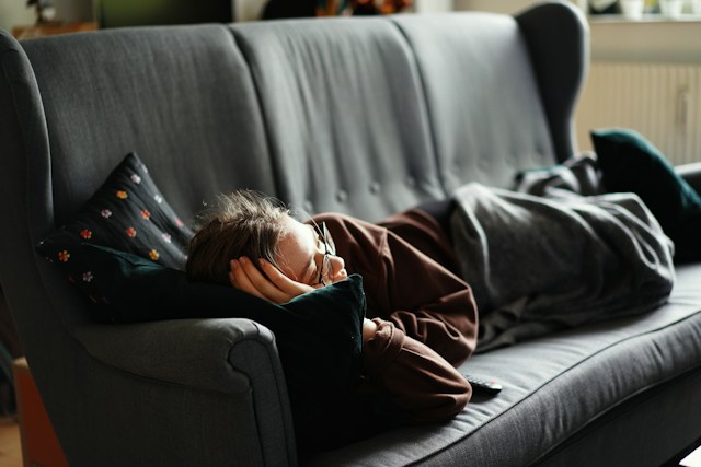 Adult resting comfortably during a short afternoon nap in a quiet, softly lit room.