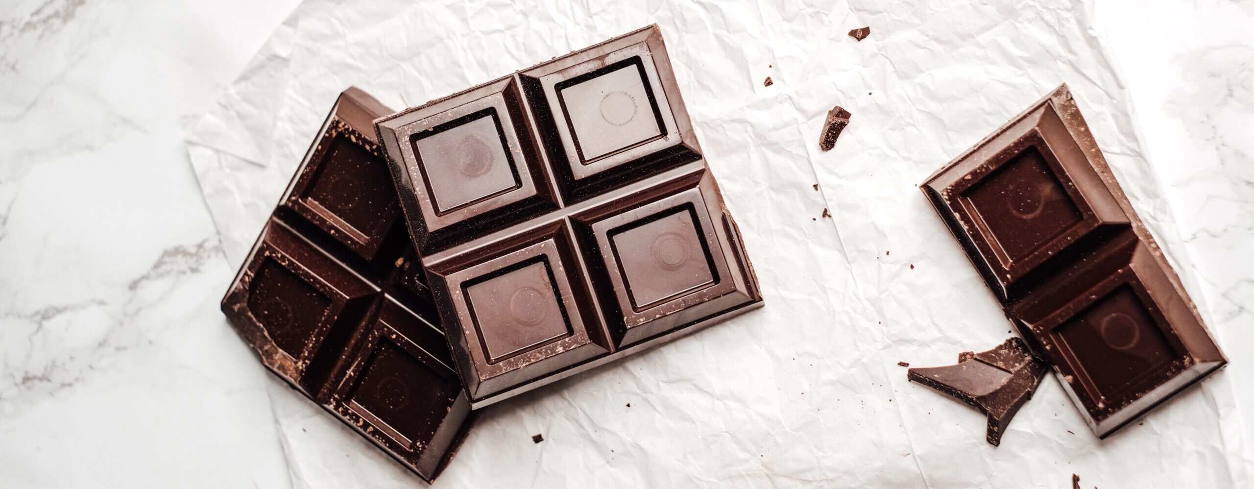 Dark chocolate pieces beside cocoa beans representing concerns about heavy metals