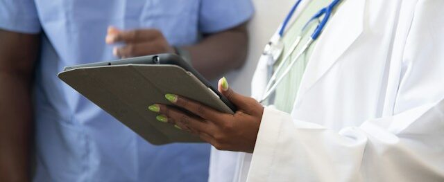 Patient reviewing a health insurance denial letter and medical bill with a healthcare advocate at a desk.