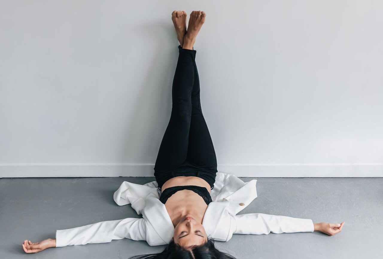 Person resting on a yoga mat with legs elevated against a wall after light exercise.